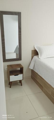 a bedroom with a bed and a mirror at Habitaciones Cataleya Valledupar in Valledupar