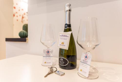 Una botella de vino y dos copas de vino en una mesa en Navigli - Vigevano 45 & Casale 3a studios, en Milán