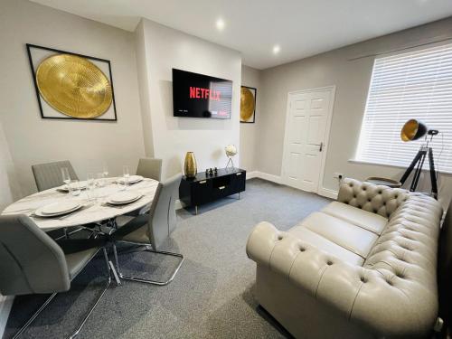 a living room with a table and a couch at Serenity By The Sea, Stylish Two Bedroom Apartment Near The Beach, South Shields in South Shields