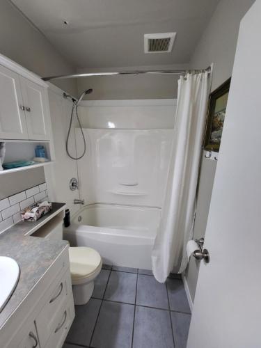 a bathroom with a white tub and a toilet at A Place to Call Home in Edmonton
