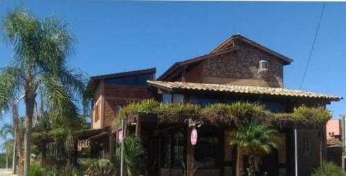 a building with palm trees in front of it at Residencial Banzaê in Garopaba