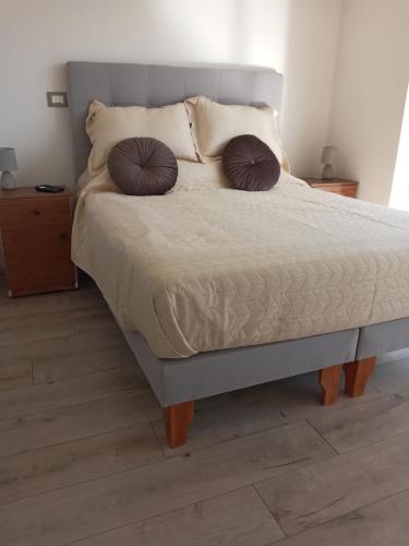 un letto con due cuscini sopra in una camera da letto di Grato y nuevo departamento a Quilpué