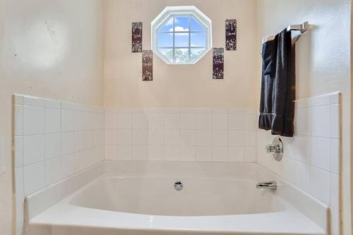 uma casa de banho branca com uma banheira e uma janela em Modern Oasis for family Escape ! em Atlanta