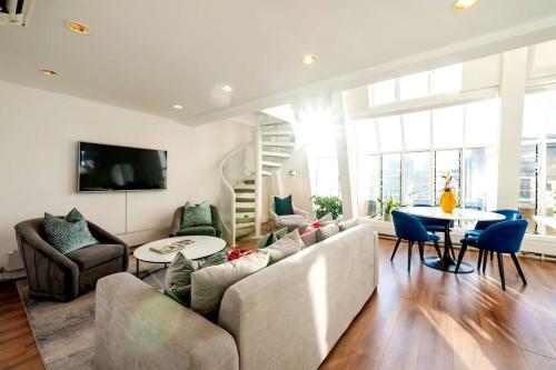a living room with a couch and a table at Arcore Premium Apartments Golden Square in London
