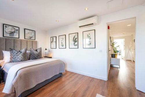 a bedroom with a large bed and some pictures on the wall at Arcore Premium Apartments Golden Square in London