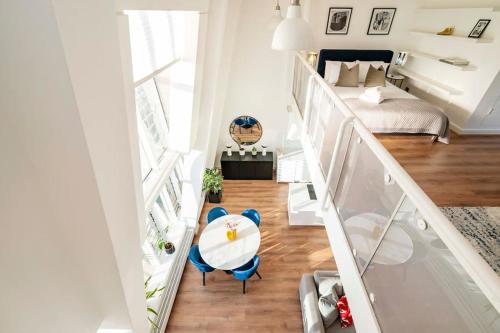 a room with a staircase with a table and blue chairs at Arcore Premium Apartments Golden Square in London