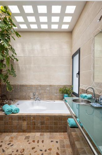 a large bathroom with a tub and a sink at Villa Leonor in Es Caló