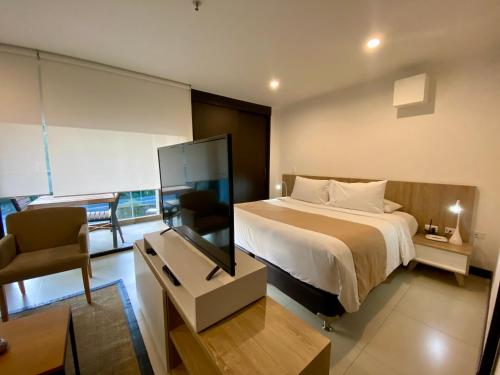 a bedroom with a bed and a desk with a television at Suite Estelar - A Pasos del Aeropuerto in Rionegro