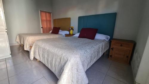 um quarto com 2 camas e uma mesa de cabeceira em madeira em Hotel Kasa 22 SMA em San Miguel de Allende