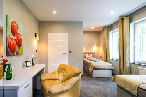 a bedroom with two beds and a chair in a room at modrakvillapark in Parłowo