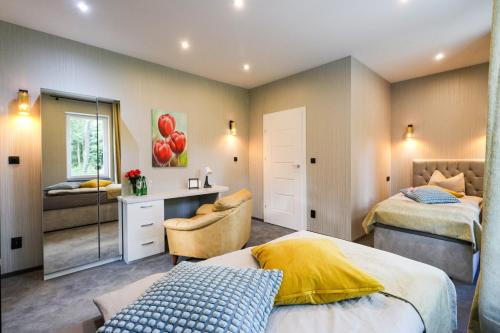 a bedroom with two beds and a desk and a mirror at modrakvillapark in Parłowo