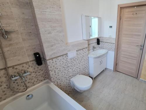 y baño con aseo, bañera y lavamanos. en Jafar Resort 9 Penthouse, en Timisoara