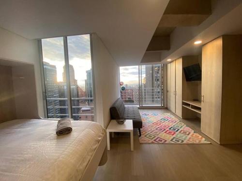 een slaapkamer met een bed en een groot raam bij Loft con vista 180° en Centro Internacional 1224 in Bogota
