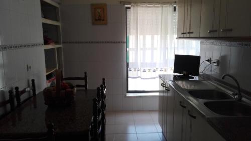 kuchnia ze zlewem i oknem w obiekcie Casa Modesta II w mieście Beja