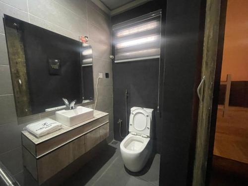a bathroom with a white toilet and a sink at The Zodiac House. in Lekki