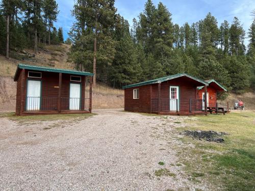 two small buildings are sitting in a field at Galena Road Cabins in Deadwood