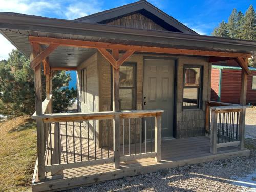 a tiny house with a porch and a door at Galena Road Cabins in Deadwood