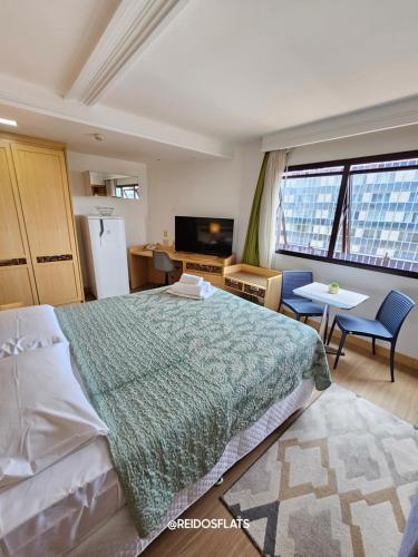 Un dormitorio con una cama, una mesa y un televisor. en Flat Lets Idea Brasília Hotel By Rei dos Flats, en Brasilia