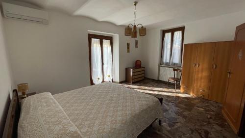 ein Schlafzimmer mit einem Bett, einer Kommode und zwei Fenstern in der Unterkunft Flowers & Angels Home in Santa Maria degli Angeli