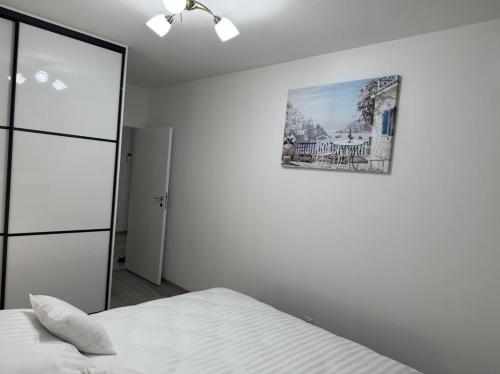 a bedroom with a bed and a picture on the wall at Apartament JANICKIEGO 166 parking free in Poznań