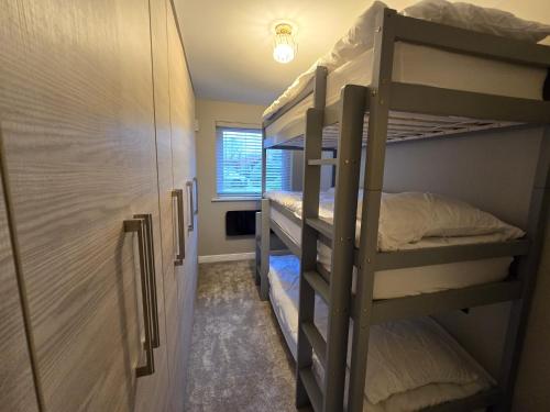 Una habitación con dos literas y un armario. en New 2 Bedroom Appartment In Manchester - Stretford - Old Trafford Close to Football-Cricket Ground & City Centre, en Mánchester