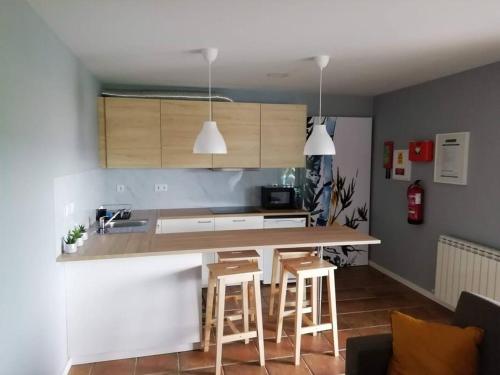 a kitchen with a counter and stools in a room at Casa da Encosta Chaves in Chaves