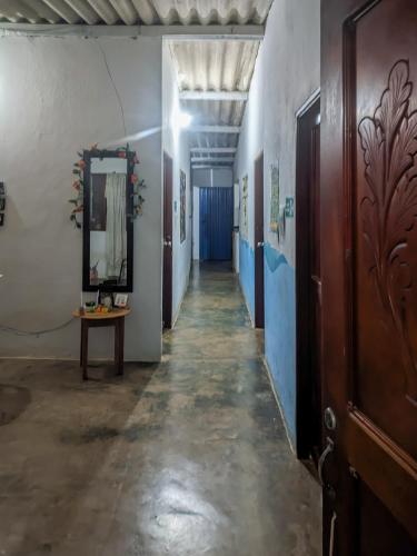 a long hallway with a mirror and a table at Hostal Palomino EcoHouse & Camping in Palomino