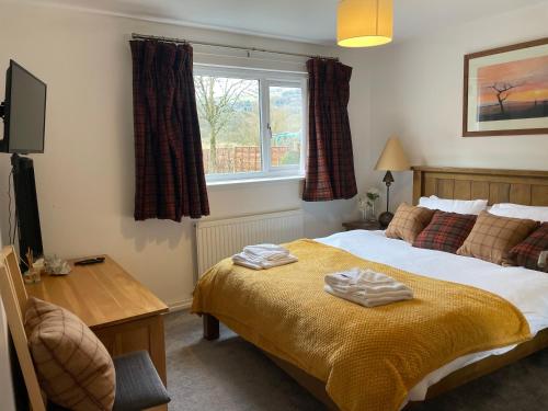 a bedroom with a bed with two towels on it at Rawtenstall bungalow. Steam train passes garden. in Rawtenstall