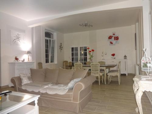 un salon avec un canapé et une salle à manger dans l'établissement Un Parfum de Campagne, à Méaulte