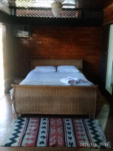 a bed in a room with a brick wall at Casa Sanca in Rio de Janeiro