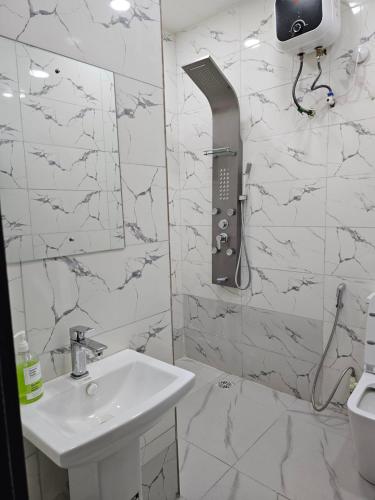 a white bathroom with a sink and a mirror at Hencapservices 001HPS in Agege