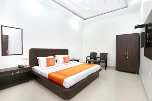 a bedroom with a large bed with orange and white sheets at Hotel Skylark in Amritsar