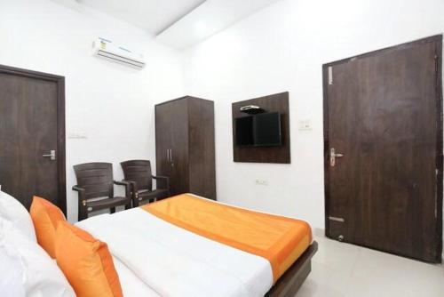 a bedroom with a bed with wooden cabinets and a tv at Hotel Skylark in Amritsar