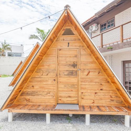 drewniane drzwi garażowe w kształcie trójkąta w obiekcie Hostel Costa Terral w mieście Matinhos