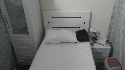 a small bedroom with a white bed with a headboard at Ruby Star Male Hostel Dubai in Dubai