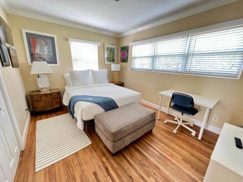 um quarto com uma cama, uma secretária e uma cadeira em La Maison-Adorable Cottage Mins from Wilton Manors em Fort Lauderdale