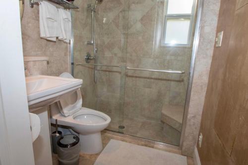 uma casa de banho com um chuveiro, um WC e um lavatório. em La Maison-Adorable Cottage Mins from Wilton Manors em Fort Lauderdale