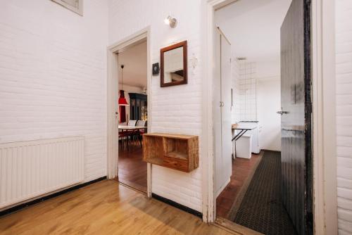 a hallway with white walls and a table in a room at Villa Zuidwest 6, Garden, Dunes & Free parking in Zandvoort