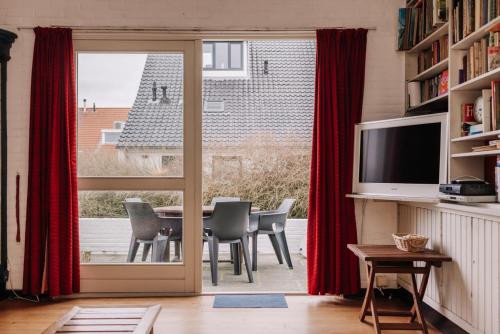 a dining room with a table and a sliding glass door at Villa Zuidwest 6, Garden, Dunes & Free parking in Zandvoort