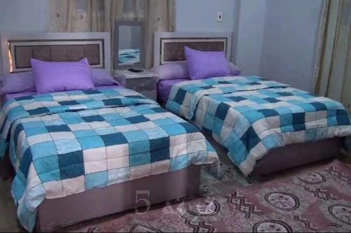 two beds sitting next to each other in a bedroom at Loulouat Al Reef in Kafr ʼakīm