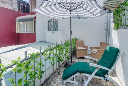 un patio con una silla y una sombrilla en Casa Amatlán Ciento Dos en Ciudad de México
