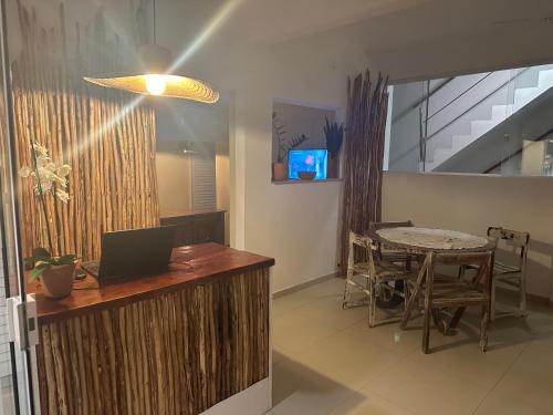 um escritório com uma secretária e uma mesa com um computador portátil em Pousada Linda flor em Morro de São Paulo