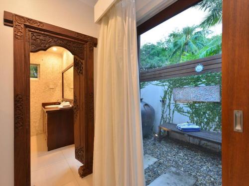 uma casa de banho com uma cortina de chuveiro e uma janela em 9 Solander Boulevard em Port Douglas