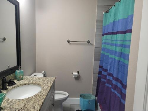 a bathroom with a sink and a colorful shower curtain at Great large home,8 min from Downtown in Pensacola