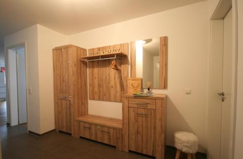 La salle de bains est pourvue d'une armoire en bois et d'un miroir. dans l'établissement Allgäustüble am See, à Schwangau
