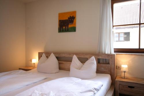 two beds with white pillows in a room with a window at Ferienwohnung Steuer in Füssen