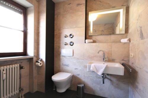 bagno con servizi igienici, lavandino e specchio di Ferienwohnung Steuer a Füssen