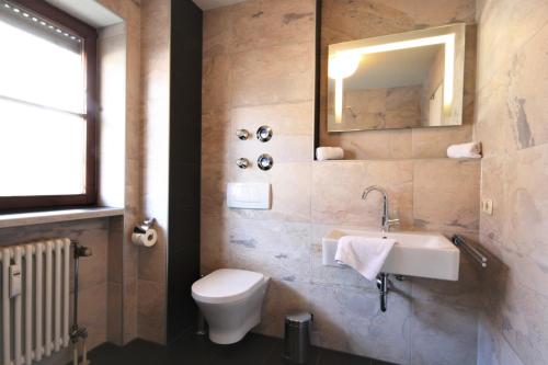 a bathroom with a toilet and a sink and a mirror at Ferienwohnung Steuer in Füssen