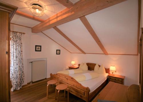 1 dormitorio con 1 cama, mesa y sillas en Alpenliebe, en Alterschrofen