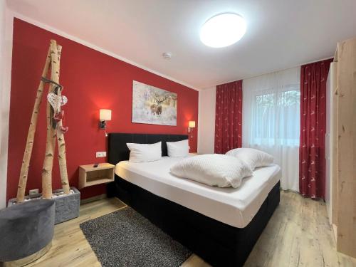 a bedroom with a large bed with a red wall at Monusse Boid Wohnung 8 in Pfronten